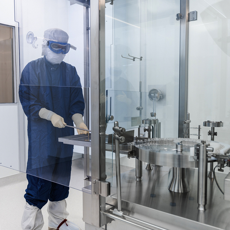 American Injectables employee operating equipment in full PPE. 