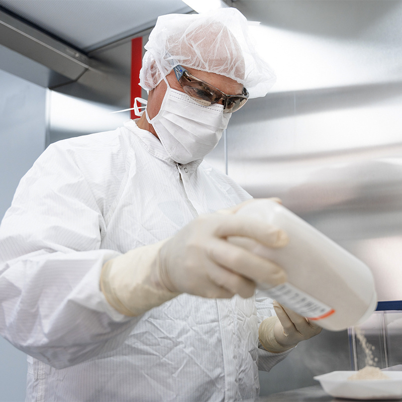 Tenured employee mixing materials in full PPE. 